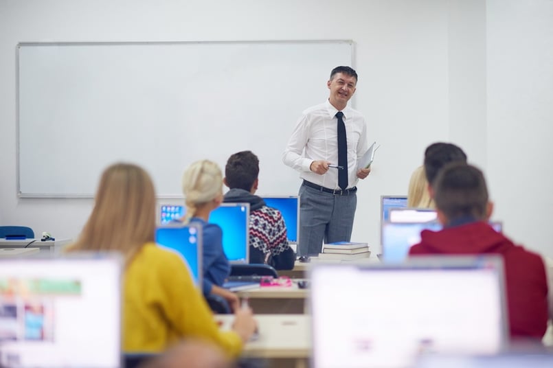 group of students with teacher in computer lab classrom learrning lessons,  get help and support.jpeg